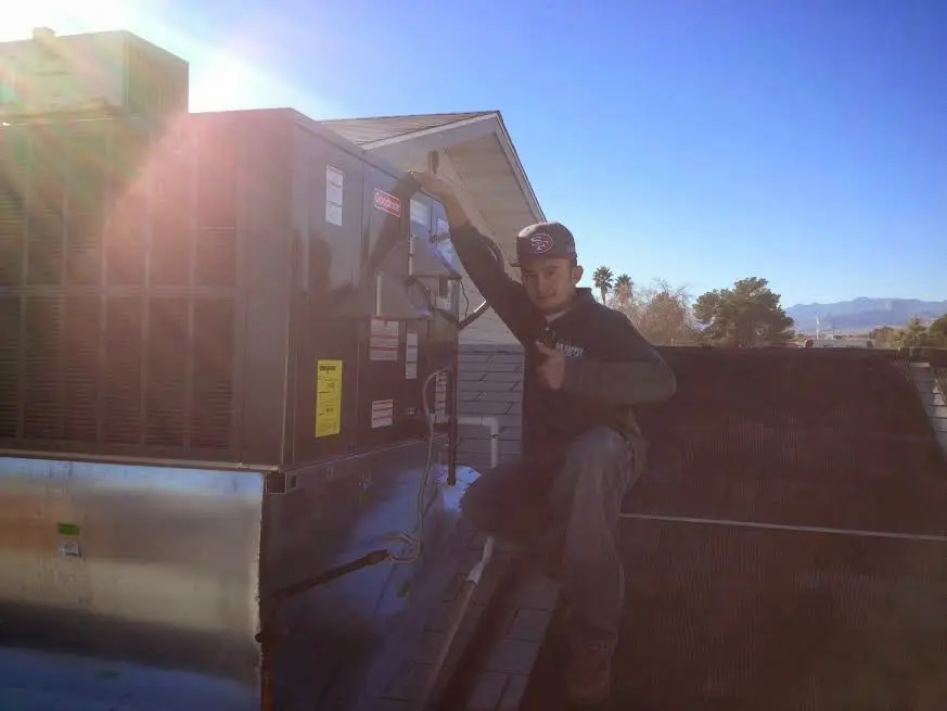 HVAC technician performing Air Duct Repair on a rooftop unit in Payette