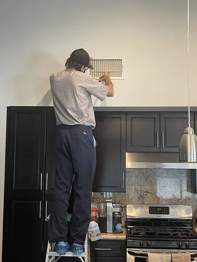 Technician inspecting an air vent during HVAC service in Payette